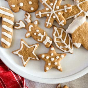Close up of sourdough gingerbread cookies on plate with christmas decor in background.