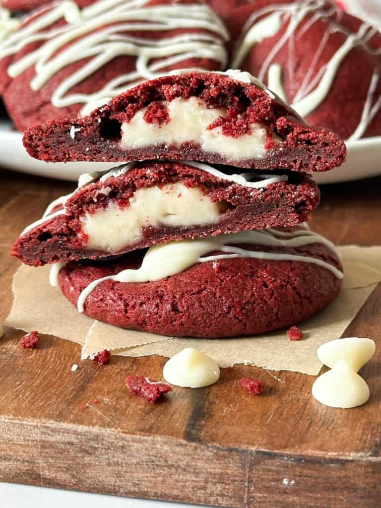 sourdough cream cheese filled red velvet cookies cut in half to reveal the cream cheese center. 