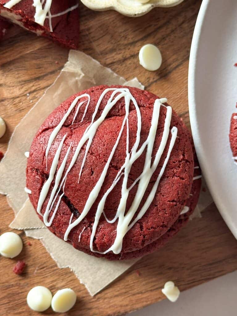 Overhead shot of sourdough red velvet cookie with white chocolate drizzle.