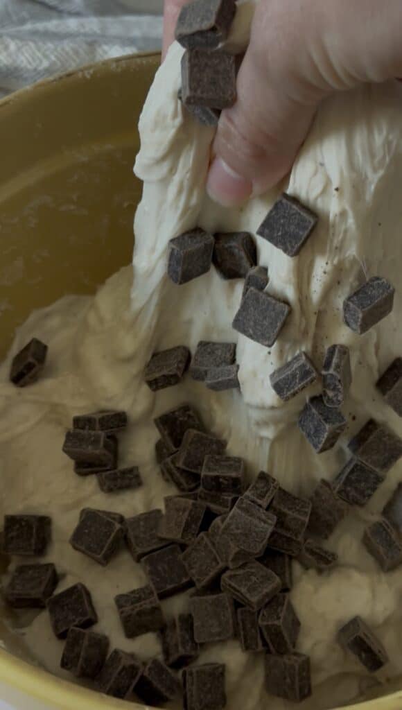 chocolate being folded into sourdough dough during stretch and fold