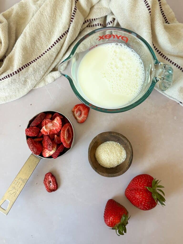 Containers filled with strawberry milk ingredients (milk, freeze dried strawberries, and sugar).