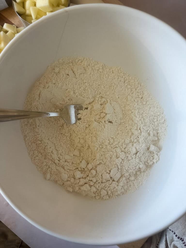 sourdough discard apple bread ingredients being whisked in a bowl.